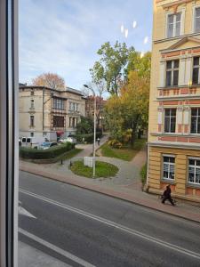 a person walking down a street next to a building at Apartament z antresolą Stare Miasto in Kłodzko