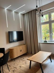a living room with a flat screen tv on the wall at Apartament z antresolą Stare Miasto in Kłodzko +12 photos