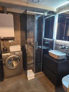 a bathroom with a washing machine and a sink at Apartament z antresolą Stare Miasto in Kłodzko