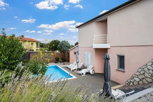 a backyard with a swimming pool and a house at Home DiE Paradise in Labin