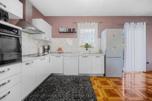 a kitchen with white cabinets and a refrigerator at Home DiE Paradise in Labin