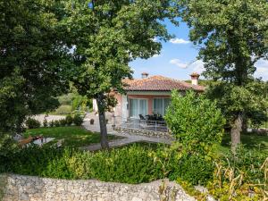 a house with a stone wall and trees at Home DiE Paradise in Labin