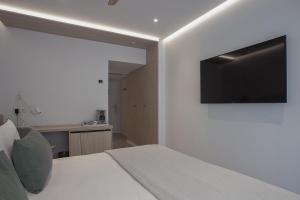 Un dormitorio con una cama con un televisor en la pared. en MIM Mallorca Member of Melia Collection, en Sa Coma