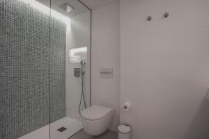 Un baño con inodoro y ducha de cristal. en MIM Mallorca Member of Melia Collection, en Sa Coma