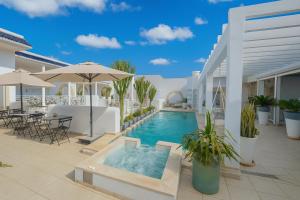 einen Pool mit Tischen und Sonnenschirmen auf einer Terrasse in der Unterkunft Dar Benti in Monastir