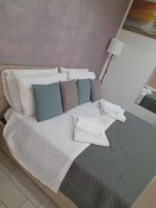 1 cama grande con sábanas blancas y almohadas azules en La Dimora Di Bruna, en Nápoles