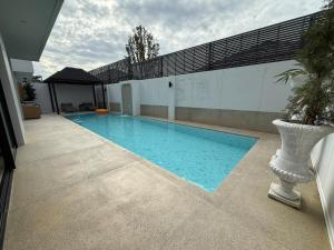 a large swimming pool on the side of a building at Bangtao Brand New Luxury Modern Pool Villa Laguna Phuket in Thalang