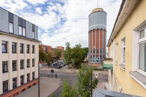 Blick auf eine Stadtstraße mit einem Uhrturm in der Unterkunft Kestutis Luxury Apartment in Šiauliai