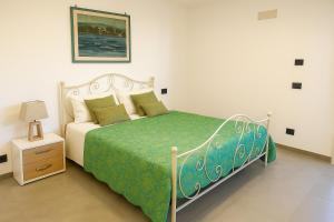 Un dormitorio con una cama con un edredón verde. en Casa Mimosa, en Isquia