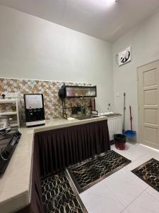 a kitchen with a counter with a stove and a sink at Zarul Homestay in Bachok +6 photos