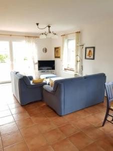 a living room with a blue couch and a table at Haus Kiki in Dornumersiel