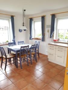 a kitchen with a dining room table and chairs at Haus Kiki in Dornumersiel