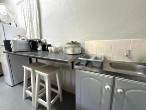 a kitchen with a counter with a sink and stools at Rus n Bietjie Guest House in Loxton +25 photos