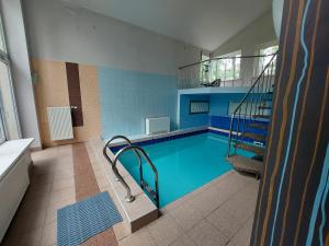 ein Schwimmbad mit Treppe in einem Gebäude in der Unterkunft Rēzijas in Ķegums
