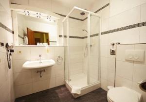 a bathroom with a shower and a sink and a toilet at Hotel an der Hörn in Kiel
