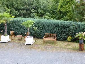 drie stoelen en een bank voor een heg bij Zum Alten Pfarrhaus - Blankenburg in Blankenburg