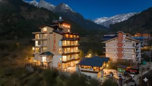 een hotelgebouw met een berg op de achtergrond bij Carom Hotel Manali in Manāli
