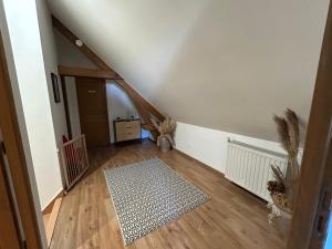 an attic room with a staircase and a hallway with a rug at Jolie maisonnette in Barenton-Bugny
