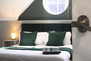 a bedroom with a bed with two cups on it at The Royal Sutton in Sutton Coldfield