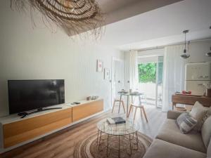 Una sala de estar con un sofá, un televisor y una mesa. en Newly renovated apartment in Málaga, en Málaga