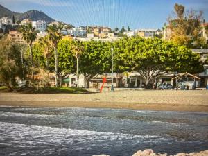 Una vista de una playa con árboles y edificios. en Newly renovated apartment in Málaga, en Málaga