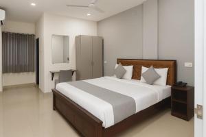 a bedroom with a large bed with white sheets at Hotel Prime Classic in Shamshabad