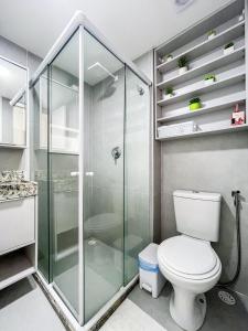 a bathroom with a toilet and a glass shower at Flat Nixxus Porto de Galinhas Ipojuca in Porto De Galinhas
