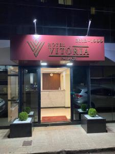 un hôtel avec une enseigne sur la façade d'un bâtiment dans l'établissement Hotel Vitoria Palace varginha, à Varginha