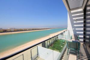 a balcony with a view of a beach and the ocean at Silk Valley - 4B near Al Hamriyah | private beach access in Sharjah