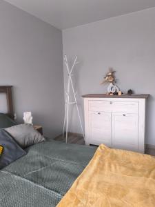 un dormitorio con una cama y una cómoda con trípode en Ludza Stay Apartment, en Ludza