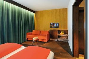 sala de estar con sofá naranja y TV en Ferienparadies Natterer See, en Innsbruck