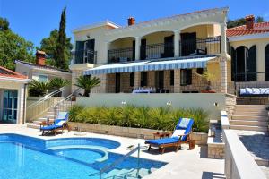 a villa with a swimming pool and a house at Beachfront Villa Gradina in Vela Luka