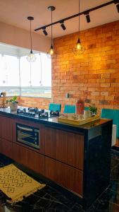 cocina con encimera, fogones y sillas azules en 9 Andar - Estilo industrial Moderno e Aconchegante, en Uberlândia