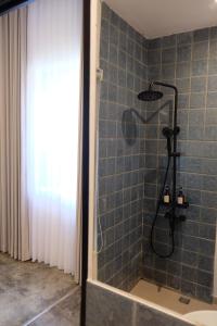 een badkamer met een douche met blauwe tegels bij Manta Rooms in Sentool