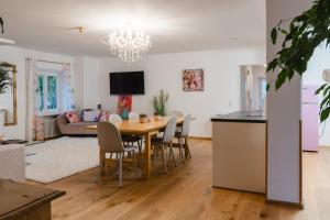 une salle à manger et un salon avec une table et des chaises dans l'établissement Ferienwohnung Jelen - Kaffee - Tee - Lichthof - 135 qm, à Kolbermoor