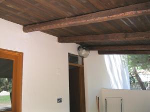 a room with a wooden ceiling and a refrigerator at Camping Costa Splendente sul mare in Le Castella