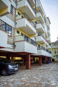 a building with a car parked in a parking lot at Micasa Pent House MAIN in Limuru
