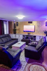 a large living room with couches and a screen at Micasa Pent House MAIN in Limuru