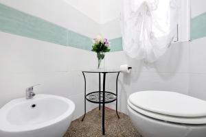 ジェノヴァにあるBenny appartamento 3 CAMERE DA LETTO ad uso ESCLUSIVO Genova Aeroportoのバスルーム(トイレ付)、テーブルに花瓶を用意しています。