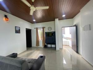 a living room with a couch and a ceiling fan at DOWN TOWN HOLIDAYS Kovalam in Kovalam