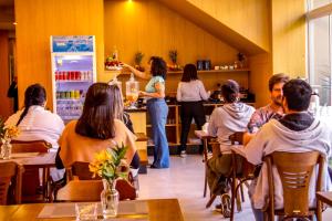 a group of people sitting at a bar in a restaurant at MLG Hotel in Mogi das Cruzes