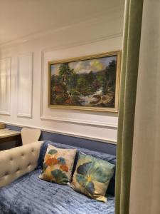 a painting on a wall above a bed with pillows at Seven seas cote Apartment in Na Jomtien