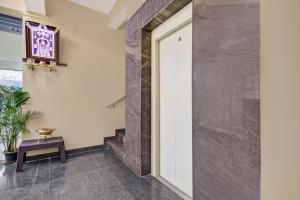 un pasillo con una puerta, un banco y una mesa en Hotel O Maruthi Paradise Netaji Udyanavana Park, en Bangalore