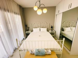 a bedroom with a white bed and two windows at Caesar Resort Lovely & Cozy 1 Bedroom Home, with Pools & Spas in İskele