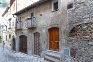 a stone building with wooden doors on a street at Oasi di Edo e Memy - B&B, hot tub, sauna, A-C, near city center in Viterbo