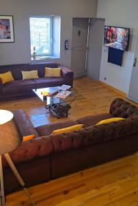 Una sala de estar con un sofá marrón y una mesa. en Le Mans 70 Duplex, 