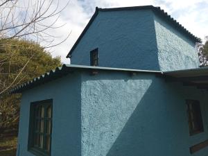 una casa azul con dos ventanas en la parte superior en Excelente casa de descanso, en Barra de Valizas