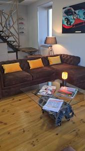 Una sala de estar con un sofá marrón y una mesa de cristal. en Le Mans 70 Duplex, 