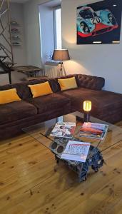 Una sala de estar con un sofá marrón y una mesa de cristal. en Le Mans 70 Duplex, 