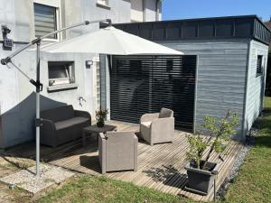a patio with an umbrella and two chairs and a table at Chez Eliane in Bennwihr